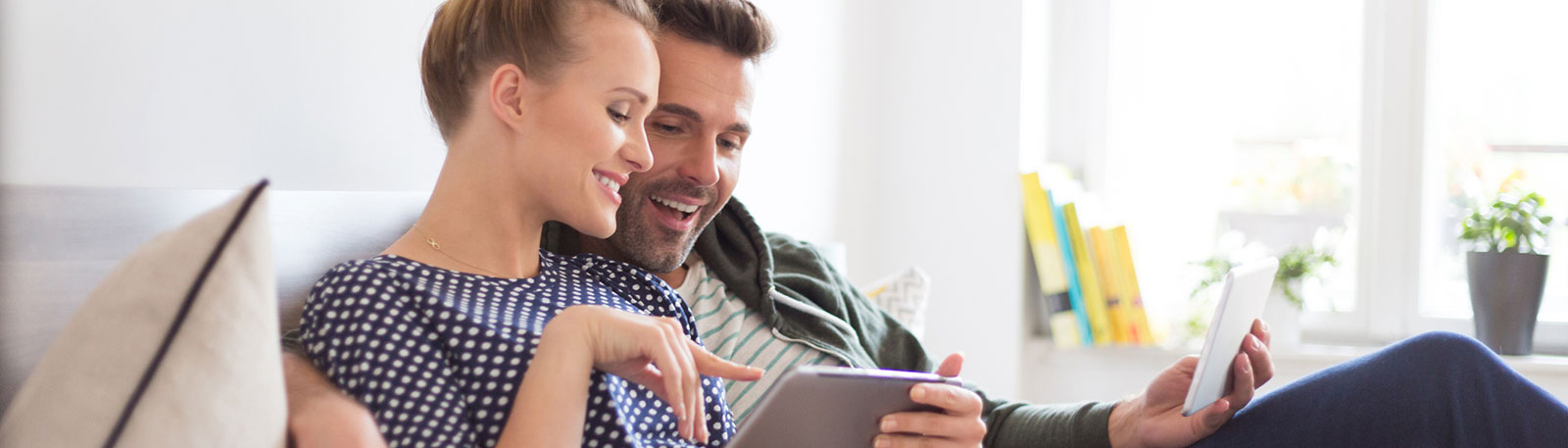 Young couple looking at tablet in living room