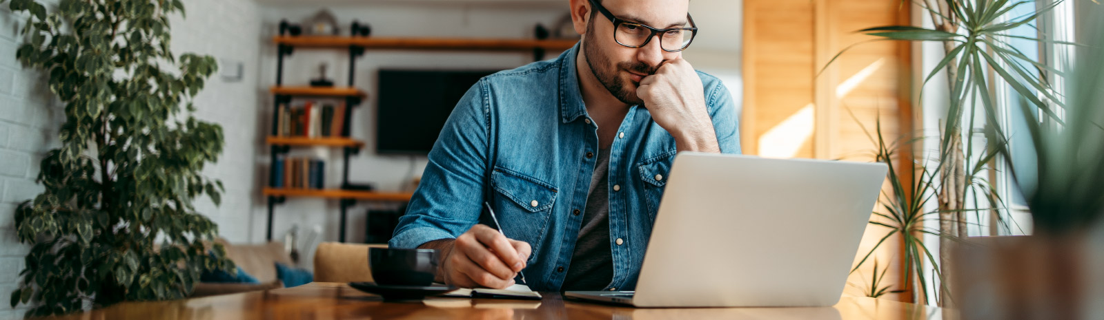 a man wearing reading glasses staring at his laptop