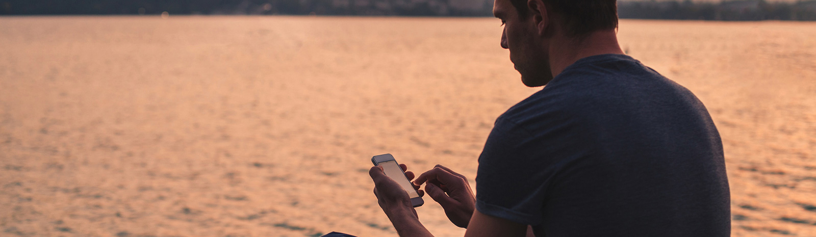 Man using phone while on lake